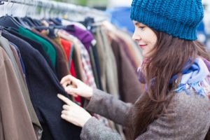 Kvinna väljer kläder på loppmarknaden